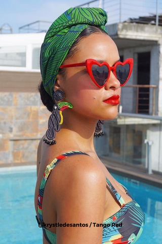 Woman wearing a bathing suit, a green turban and Bésame's red lipstick poolside