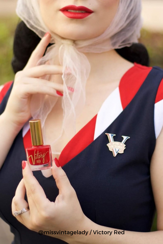 Vintage style woman holding a Bésame's cruelty-free red lipstick